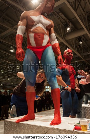 MILAN, ITALY - FEBRUARY 8: Bodybuilders during body painting session at Milano Tattoo Convention, international event dedicated to tattoos, body piercing and body painting on FEBRUARY 8, 2014 in Milan