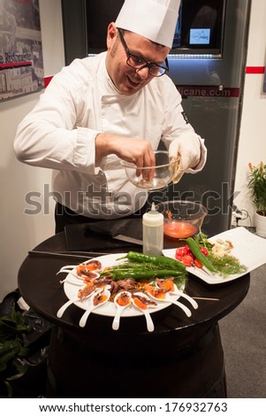 MILAN, ITALY - FEBRUARY 13: Cook prepares finger food at Bit, international tourism exchange reference point for the travel industry on FEBRUARY 13, 2014 in Milan.