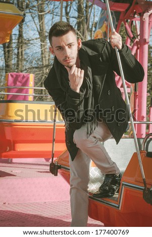 Portrait of a handsome young man with scarf on amusement ride