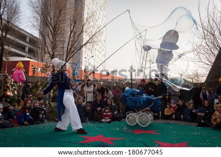 MILAN, ITALY - MARCH 8: Artist creates giant soap bubbles at Milan Clown Festival, international event dedicated to clowns and street theatre on MARCH 8, 2014 in Milan.