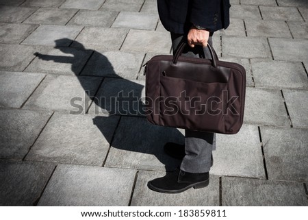Shadow of a businessman with phone standing