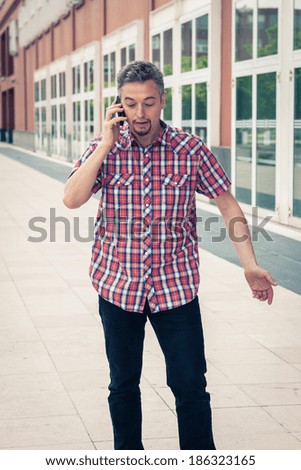 Man in short sleeve shirt talking on phone in the street