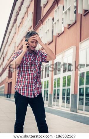 Man in short sleeve shirt talking on phone in the street