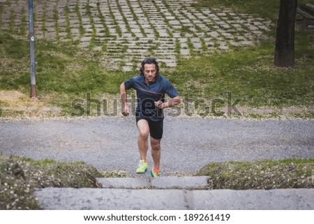 Mature long haired athlete running in a city park