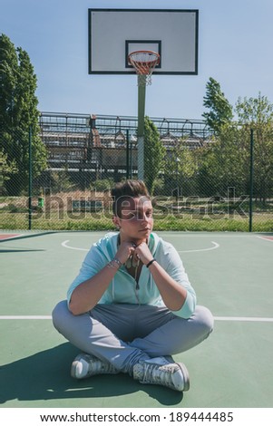 Short hair girl with hoodie in a basketball playground