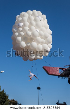 MILAN, ITALY - SEPTEMBER 6: Dancer performs hanging from balloons at the Color Run event, the funniest and most colorful urban running ever on SEPTEMBER 6, 2014 in Milan.