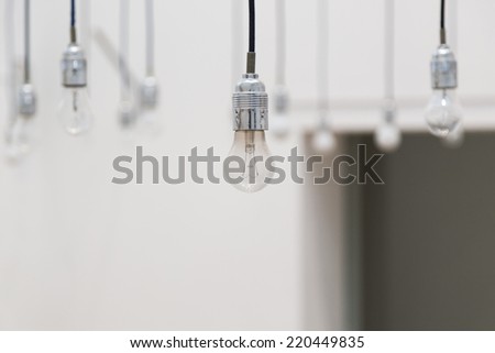Hanging light bulbs on blurred white background