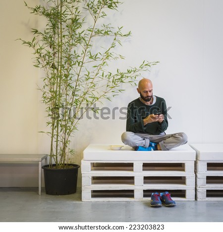 MILAN, ITALY - OCTOBER 10: Man texting at Yoga Festival, event dedicated to yoga, meditation and healthy lifestyle on OCTOBER 10, 2014 in Milan.