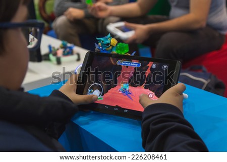 MILAN, ITALY - OCTOBER 24: People play at Games Week 2014, event dedicated to video games and electronic entertainment on OCTOBER 24, 2014 in Milan.