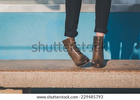 Detail of ankle boots on bench in a metro station