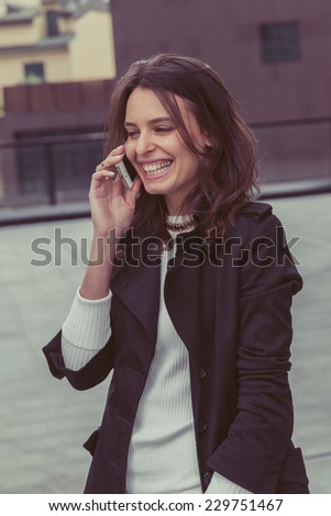 Pretty girl talks on phone in the city streets