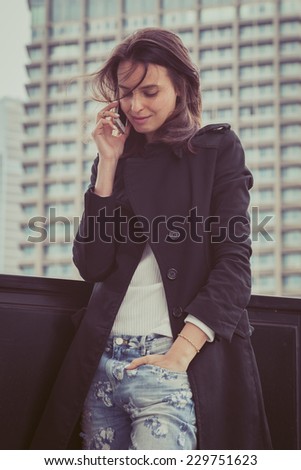 Pretty girl talks on phone in the city streets