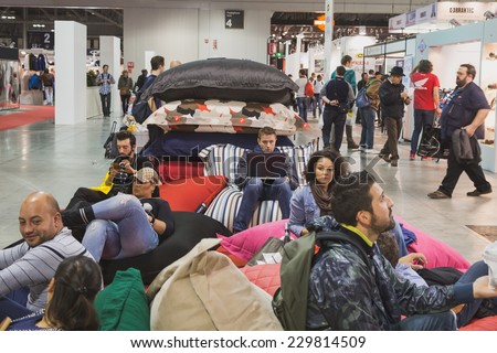 MILAN, ITALY - NOVEMBER 5: People take a rest at EICMA, international motorcycle exhibition on NOVEMBER 5, 2014 in Milan.