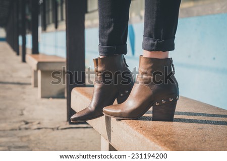 Detail of ankle boots on bench in a metro station