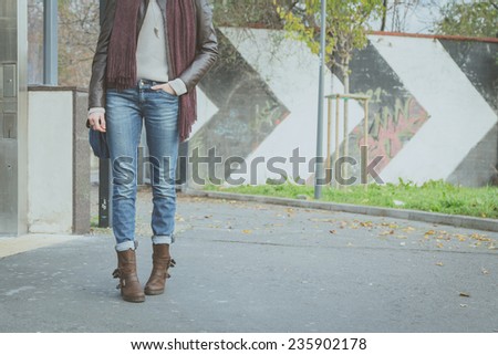Detail of a young woman with jeans posing in the street
