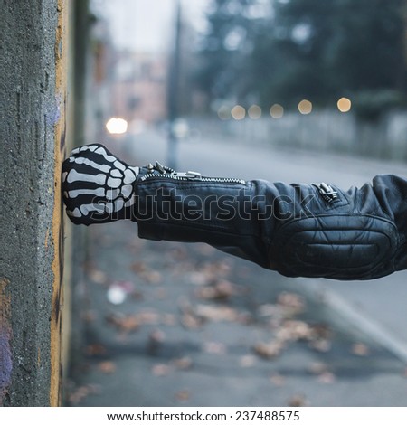 Detail of a punk guy with gloves posing in the city streets