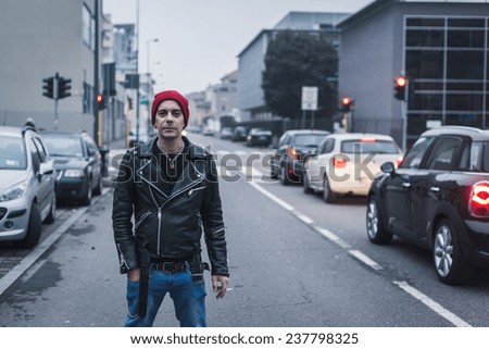 Punk guy with beanie posing in the city streets