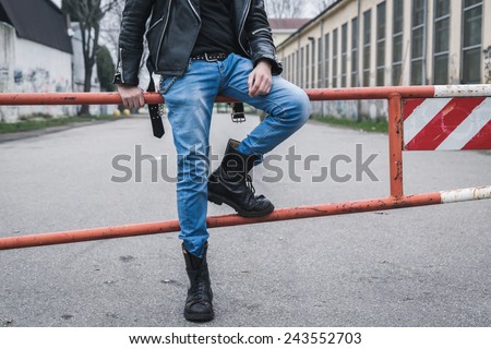 Punk guy with boots posing in the city streets