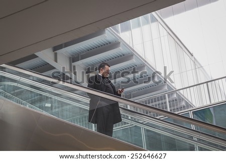 MILAN, ITALY - FEBRUARY 13: Man on escalator visits Bit, international tourism exchange reference point for the travel industry on FEBRUARY 13, 2015 in Milan.