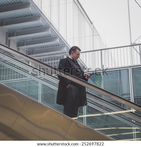 MILAN, ITALY - FEBRUARY 13: Man on escalator visits Bit, international tourism exchange reference point for the travel industry on FEBRUARY 13, 2015 in Milan.
