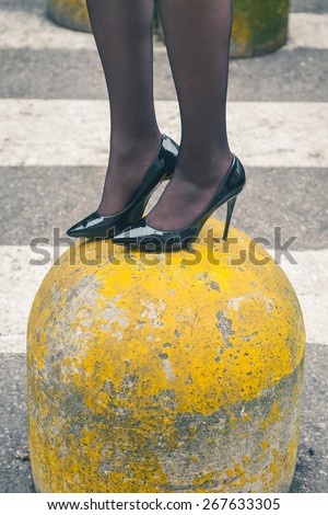 Detail of a young woman wearing high heels in an urban context
