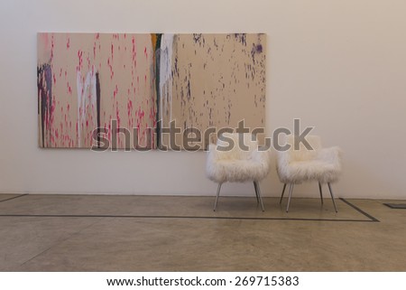 MILAN, ITALY - APRIL 14: Paintings and chairs on display at Fuorisalone at Ventura Lambrate space, location of important events during Milan Design Week on APRIL 14, 2015 in Milan.