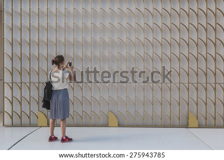 MILAN, ITALY - MAY 6:Woman takes a pic outside Bahrain pavilion at Expo, universal exposition on the theme of food on MAY 6, 2015 in Milan.