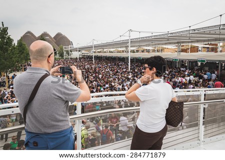 MILAN, ITALY - JUNE 1: Man takes a picture of the crowd at Expo, universal exposition on the theme of food on JUNE 1, 2015 in Milan.