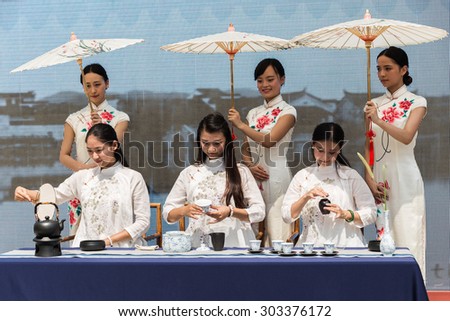MILAN, ITALY - AUGUST 3: Beautiful Chinese girls perfom tea ceremony at Expo, universal exposition on the theme of food on AUGUST 3, 2015 in Milan.