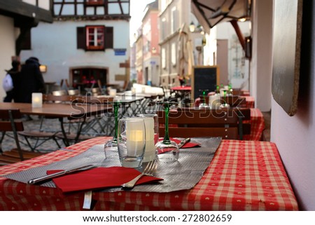 Open air street cafe or restaurant in the medieval Petite-France district at twilight - France, Alsace region, Strasbourg