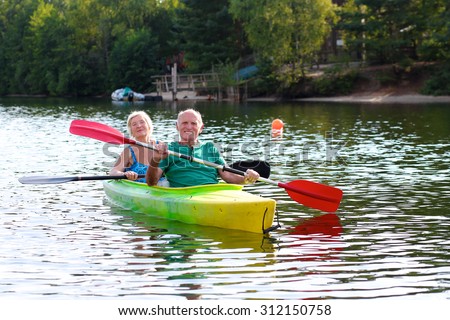 Senior couple kayaking on the river. Healthy elders enjoying summer day outdoors. Sportive people having fun at the nature. Active retirement concept.