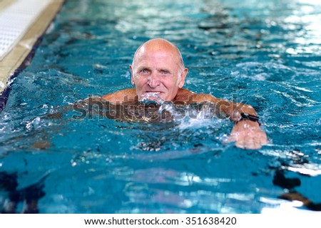 Healthy senior man swimming in the pool. Happy pensioner enjoying sportive lifestyle. Active retirement concept.