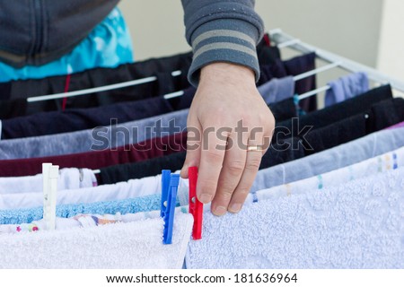 Man hands hanging wet clothes on clothes-line for drying
