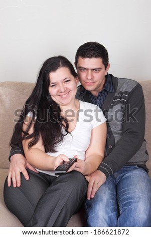 Young couple sitting with comfort on couch and watching TV