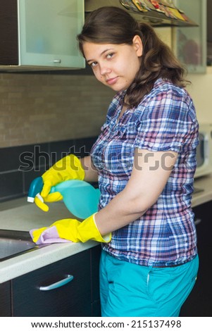 Attractive young woman cleaning sink at the kitchen