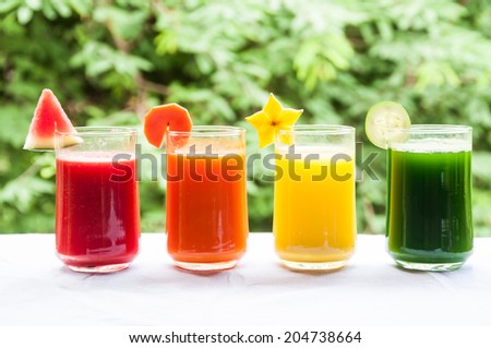 Four glasses of colorful drink of fruit and vegetable juice for good health