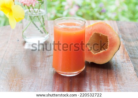 Papaya juice and papaya fruit on wood table