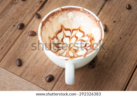 Stain of latte art coffee in white cup on wooden background after drink