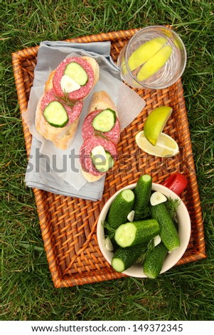 Homemade fresh salted cucumbers in the bowl and sandwiches with smoked sausage