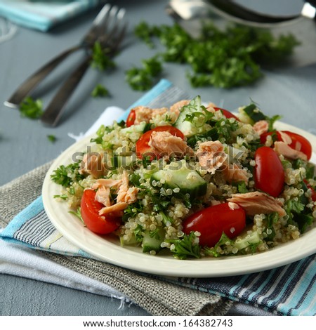 Tabbouleh salad with quinoa, salmon, tomatoes, cucumbers and parsley
