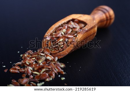 Broken flax seeds in wooden scoops (contain a lot of fiber)