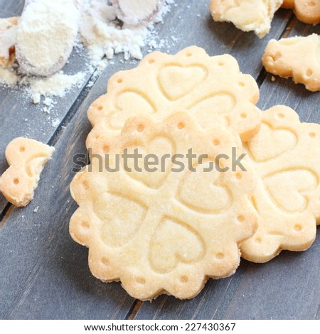 Homemade gluten free shortbread cookies with scoops of gluten free flour on old wooden background,  viewed from above