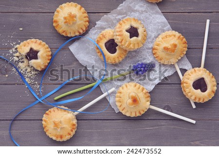 Homemade shortbread cookies on a stick on wooden background, toned