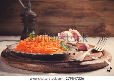 Spicy Korean style carrot salad on metal plate with spices. Selective focus. Rustic style. Toned