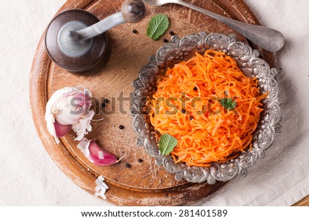 Delicious and spicy carrot spaghetti with ginger, garlic, chili and olive oil on round chopping board. Top view.