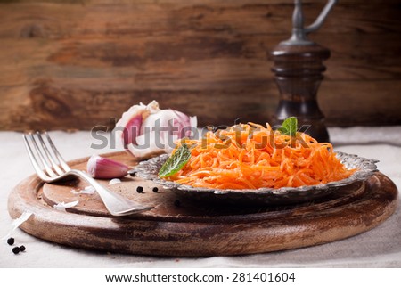 Spicy Korean style carrot salad on metal plate with spices. Selective focus. Rustic style.