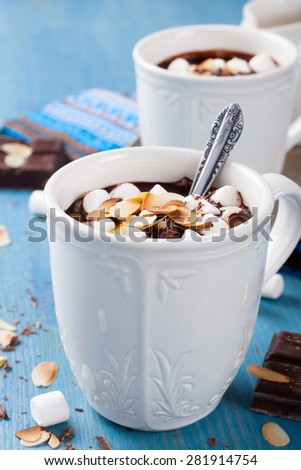 Two cups of chocolate almond milk with marshmallow and almond chips. Selective focus