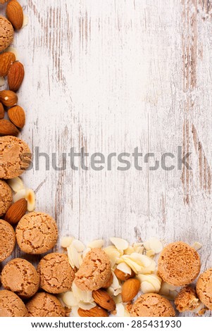 Background with italian almond cookie amaretti and almonds on white vintage table, food concept with copy space, top view.