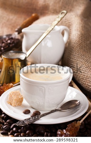 Cup of coffee, old coffee pot and coffee beans on wooden rustic background. Selective focus.