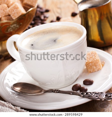 Cup of coffee, old coffee pot and coffee beans on wooden rustic background. Selective focus.